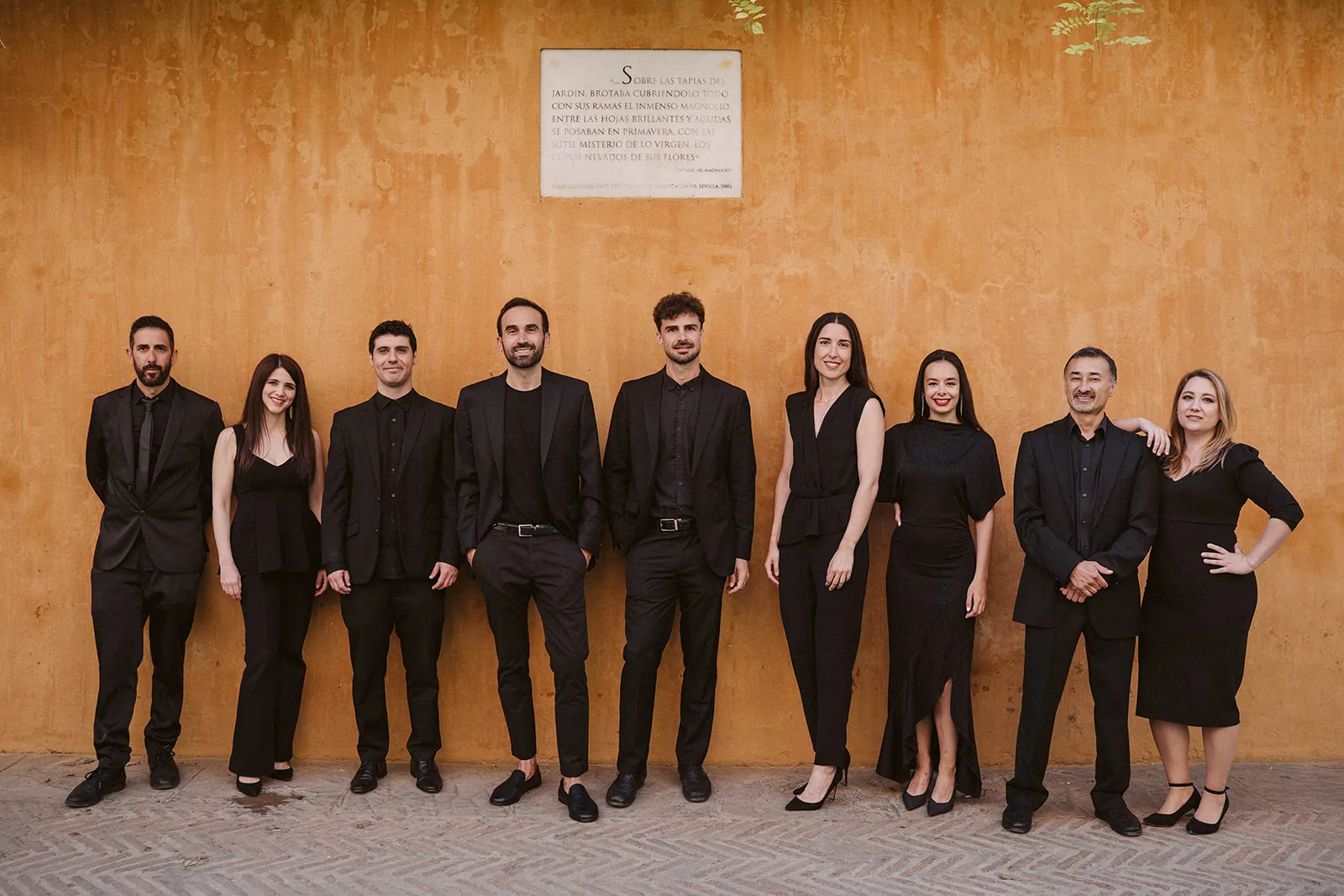 The Música Para Boda team against an ochre wall in Seville